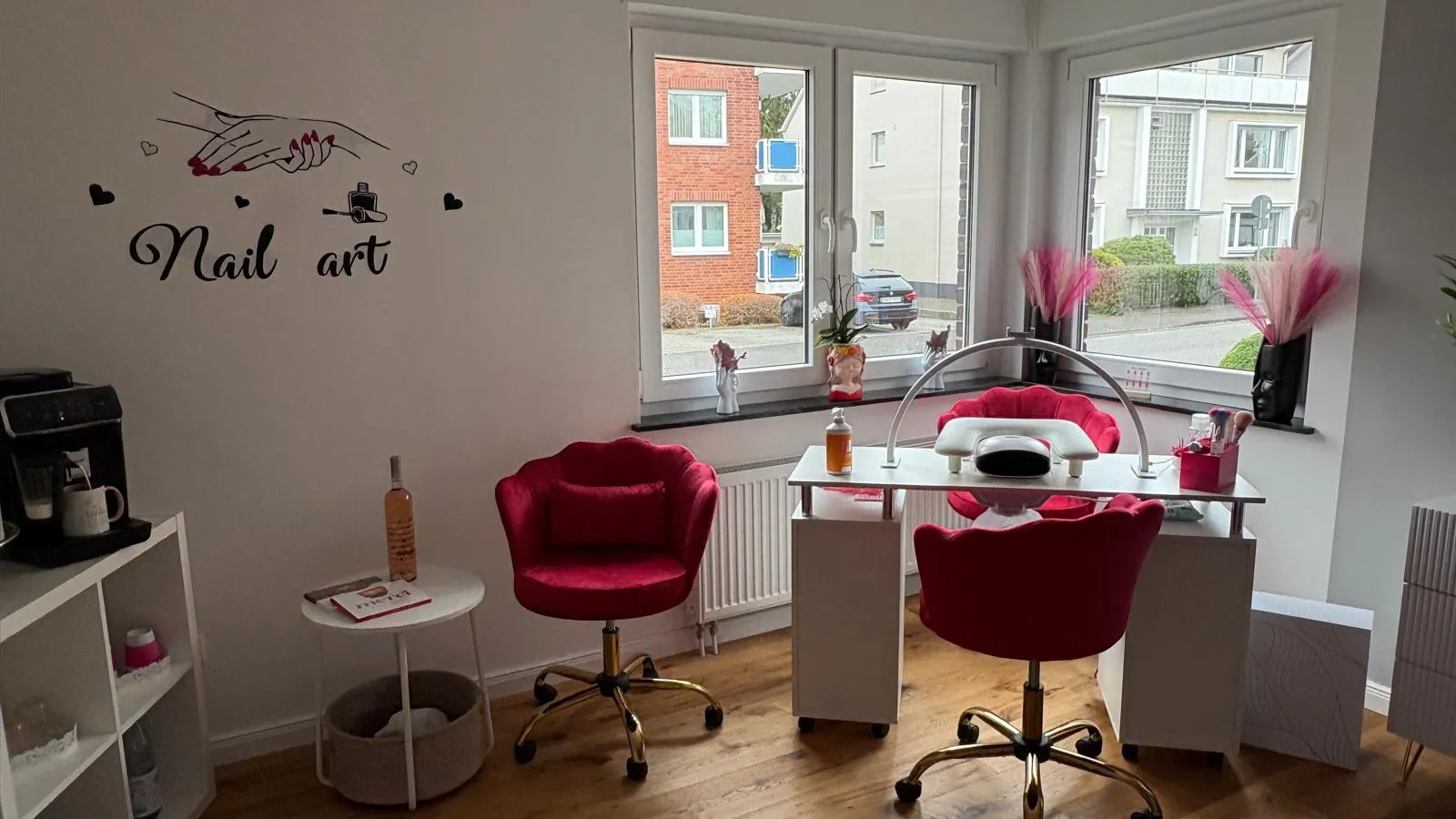 Manikürtisch mit roten Samtstühlen und UV-Härtungsgerät